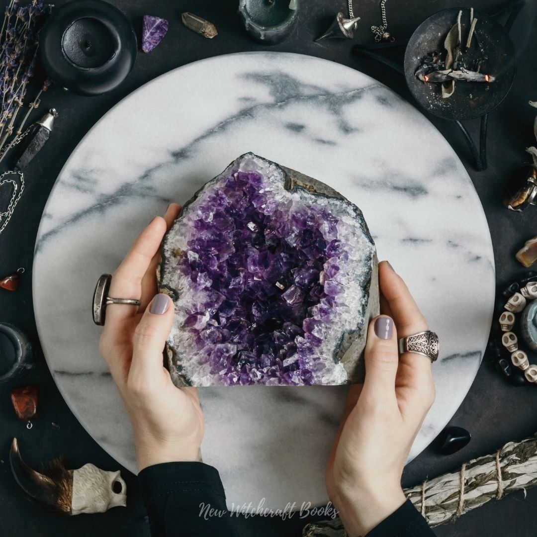 Two hands holding an Amethyst